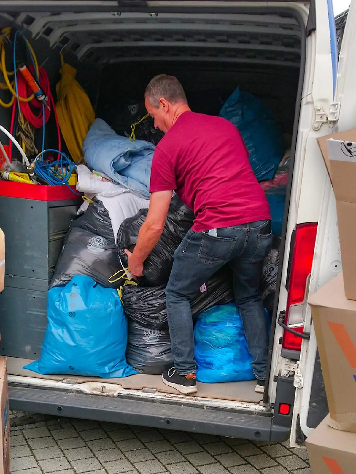 Freiwillige  Helfer verladen die vielen Sachspenden in Transporter.
