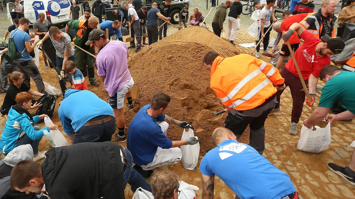 16.07.2021, Nordrhein-Westfalen, Erftstadt: Viel Helfer befüllen Sandsäcke. Sie werden benötigt, um Dämme zu sicher, die vom Hochwasser aufgeweicht sind. Foto: David Young/dpa +++ dpa-Bildfunk +++