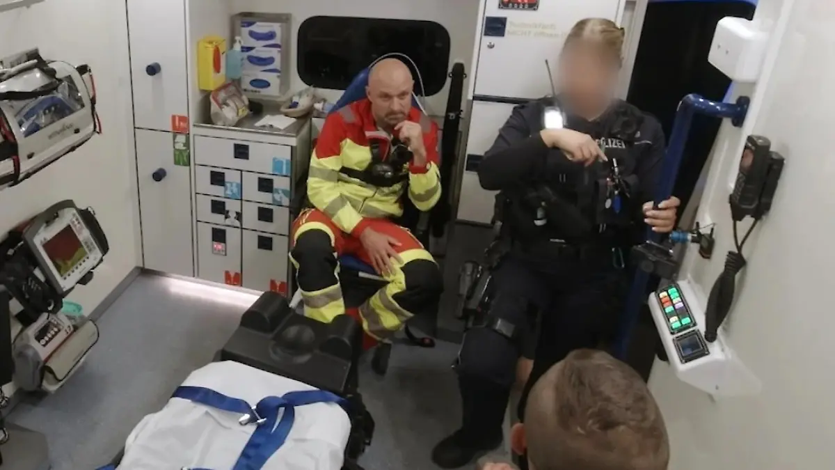 Patient, Polizistin und Sanitäter im RTW