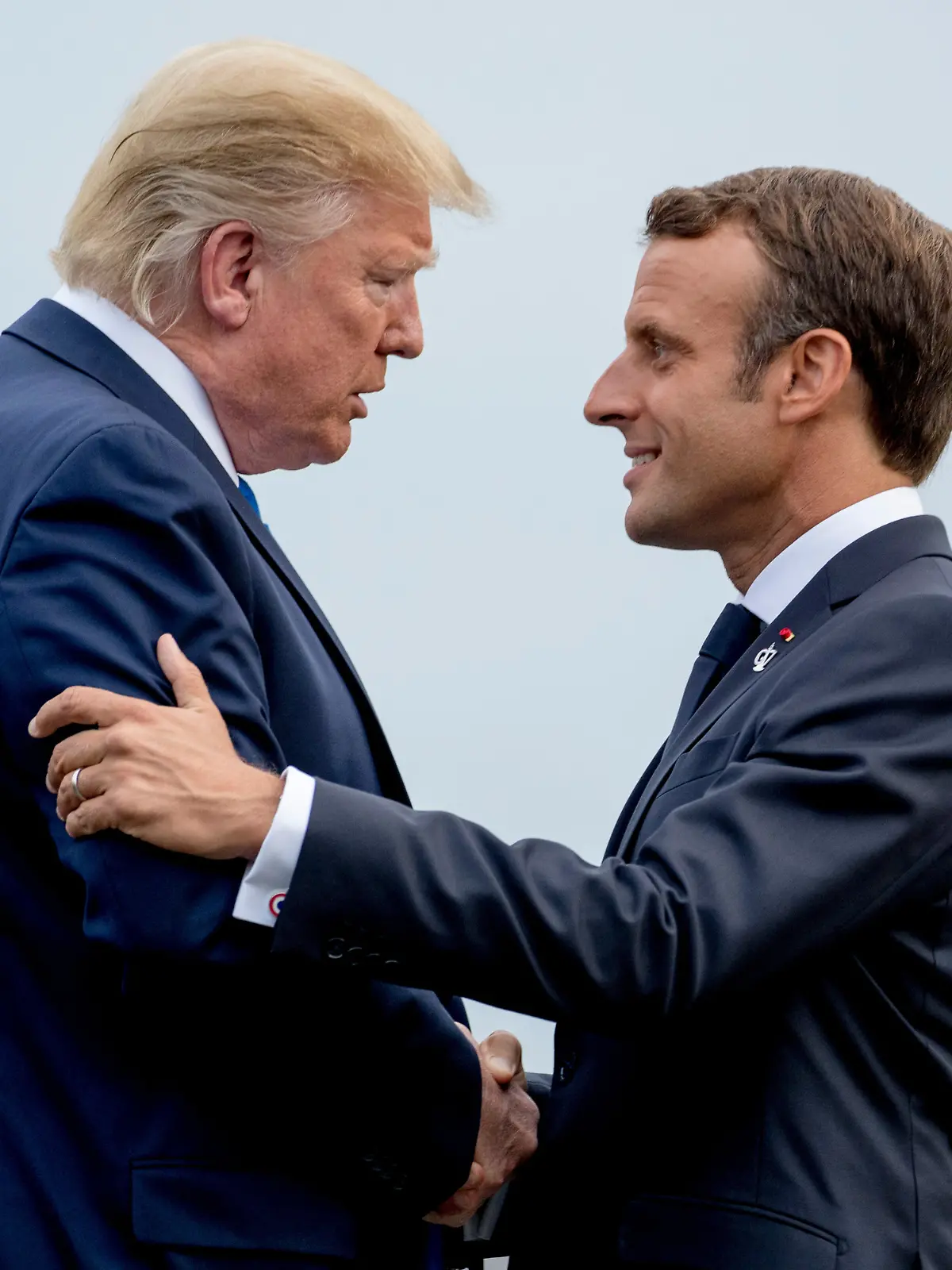 FILE - President Donald Trump and French President Emmanuel Macron greet each other at the G-7 summit before a dinner at the Lighthouse of Biarritz, France, Aug. 24, 2019. (AP Photo/Andrew Harnik, File)