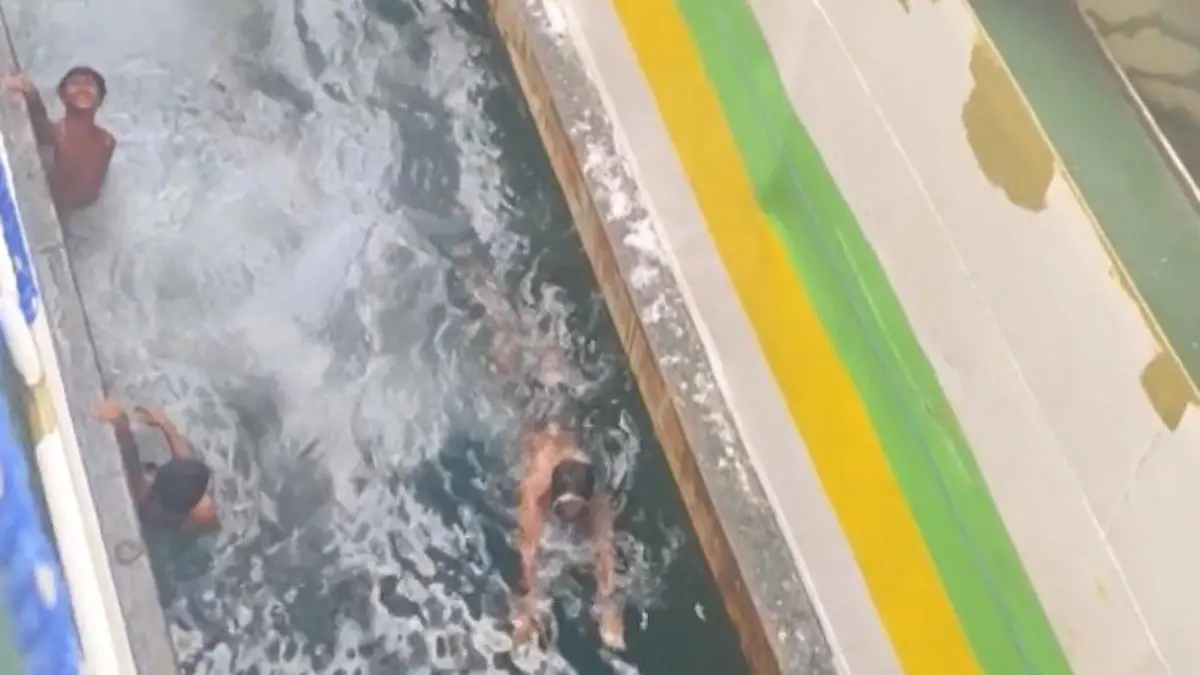 Einquetsch-Gefahr! Jungen schwimmen zwischen Fähren – um Touris zu unterhalten Schock-Attraktion vor den Philippinen