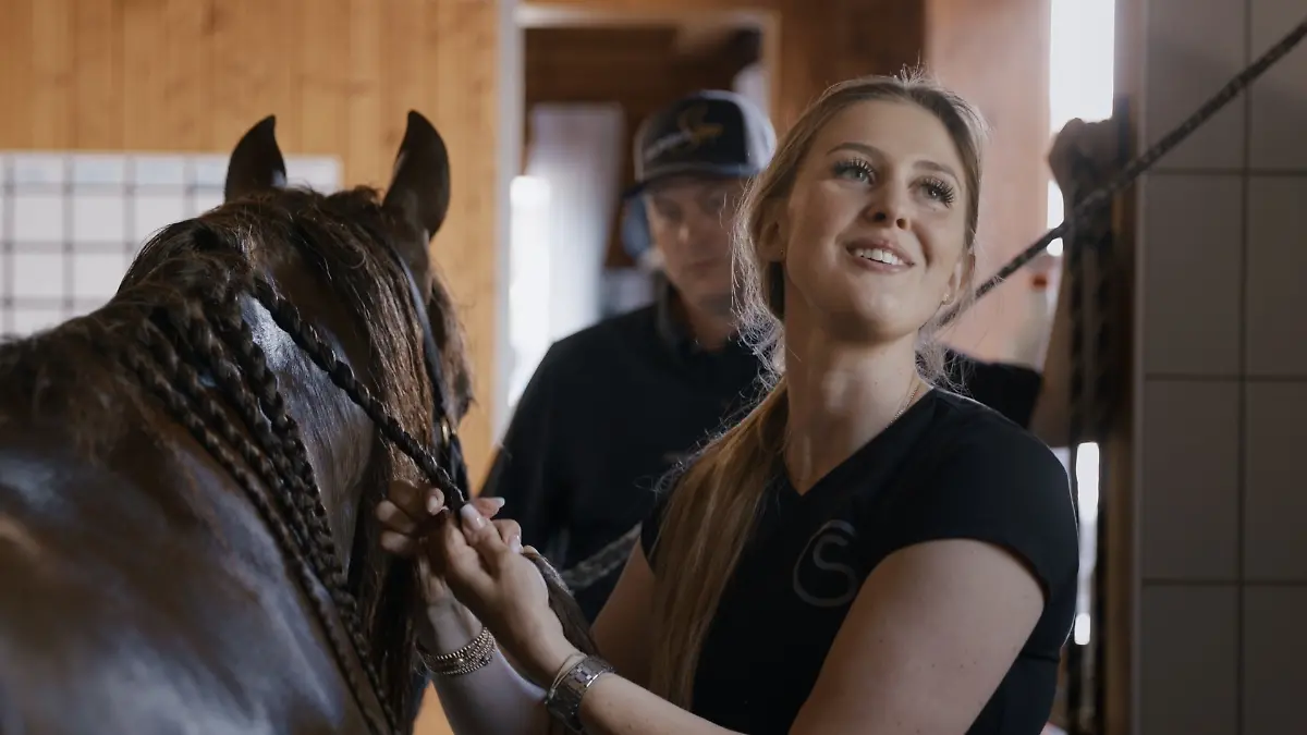 Gina Schumacher mit einem ihrer Pferde. Im Hintergrund zu sehen: ihr Mann Iain Bethke.