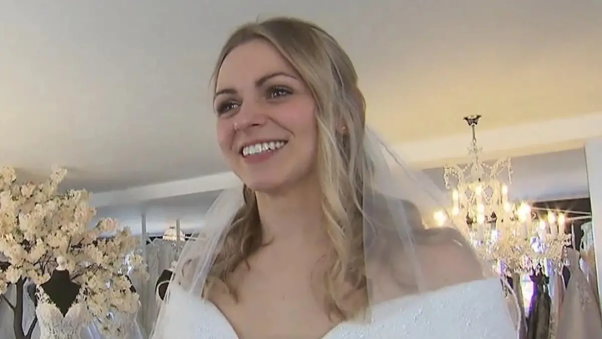 Adriana lächelt im Brautkleid mit Schleier