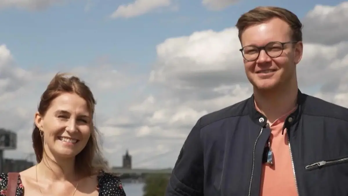 Eine Frau und ein Mann stehen am Ufer eines Flusses