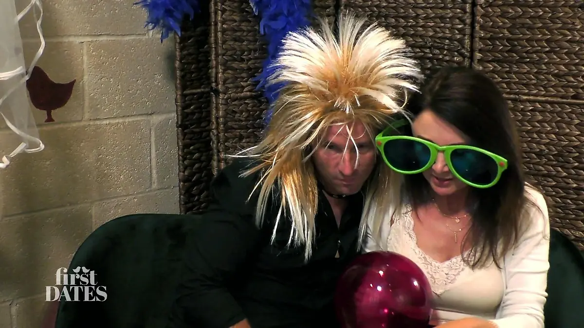 First Dates – Ein Tisch für zwei: Stefan mit wilder blonder 80er-Jahre-Perücke und Beata mit riesiger grüner Sonnenbrille in der Fotobox