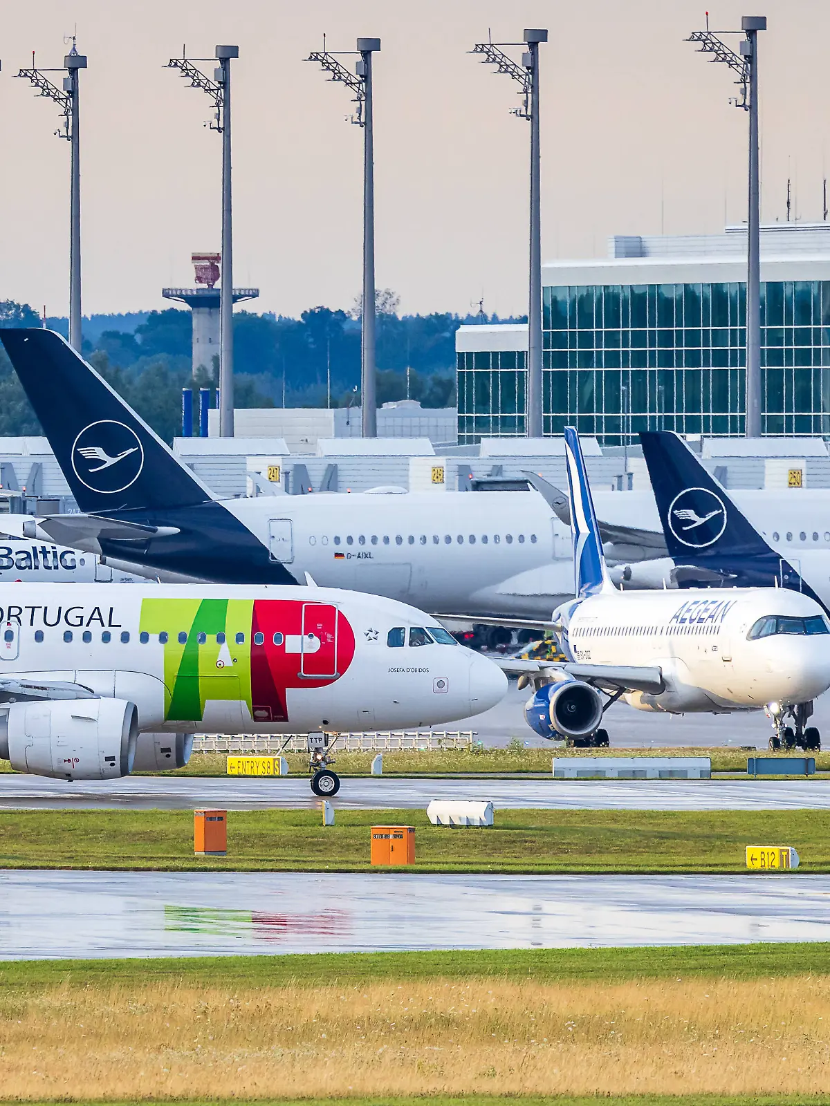 Abendlicher Flugbetrieb auf Start- und Landebahn des Münchner Flughafens, Oberding, 15.07.2025 Ein Passagierflugzeug der portugiesischen Fluggesellschaft TAP Air Portugal mit der Registrierung CS-TTP rollt am Flughafen München vor mehreren abgestellten Maschinen, darunter Flugzeuge von airBaltic, Aegean Airlines und Lufthansa. Die abgebildete Maschine ist ein Airbus A319. TAP ist Mitglied der Star Alliance, und es bestehen aktuell Verhandlungen über eine mögliche Integration in die Lufthansa Group. Oberding Bayern Deutschland *** Evening flight operations on the runway at Munich Airport, Oberding, 15 07 2025 A passenger aircraft of the Portuguese airline TAP Air Portugal with the registration CS TTP taxis at Munich Airport in front of 20250714-286A5918-M4000