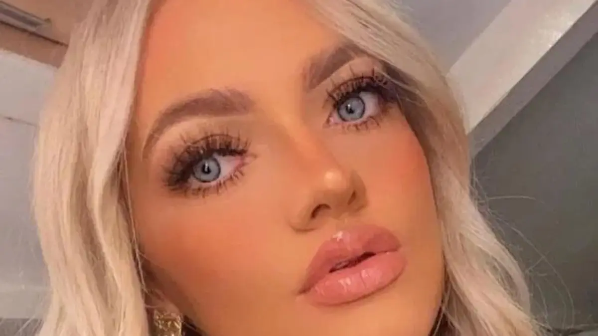 Ein blondes Mädchen mit blauen Augen macht ein Selfie von sich.