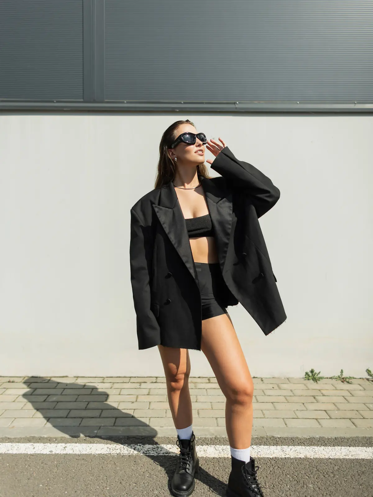 Modernes Streetstyle-Porträt einer modischen Frau in einem monochromen Outfit mit Sonnenbrille und Stiefeln. Modische, hübsche, urbane Dame mit Sonnenbrille. *** Modern Streetstyle Portrait a fashionable Woman in a monochrome Outfit with Sunglasses and Boots Fashionable, pretty, urban Lady with Sunglasses 1102832124