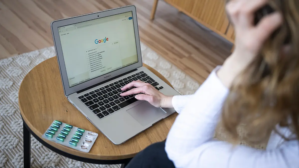 Eine Person gibt in die Google-Suche «Kopfschmerzen was tun» ein, daneben liegen Tabletten in einer Blisterpackung. Viele Menschen informieren sich online zu gesundheitlichen Beschwerden, was neben Informationen auch Verunsicherung auslösen kann. (zu dpa: «Cyberchondrie: Googeln, bis man zum Arzt muss») +++ dpa-Bildfunk +++