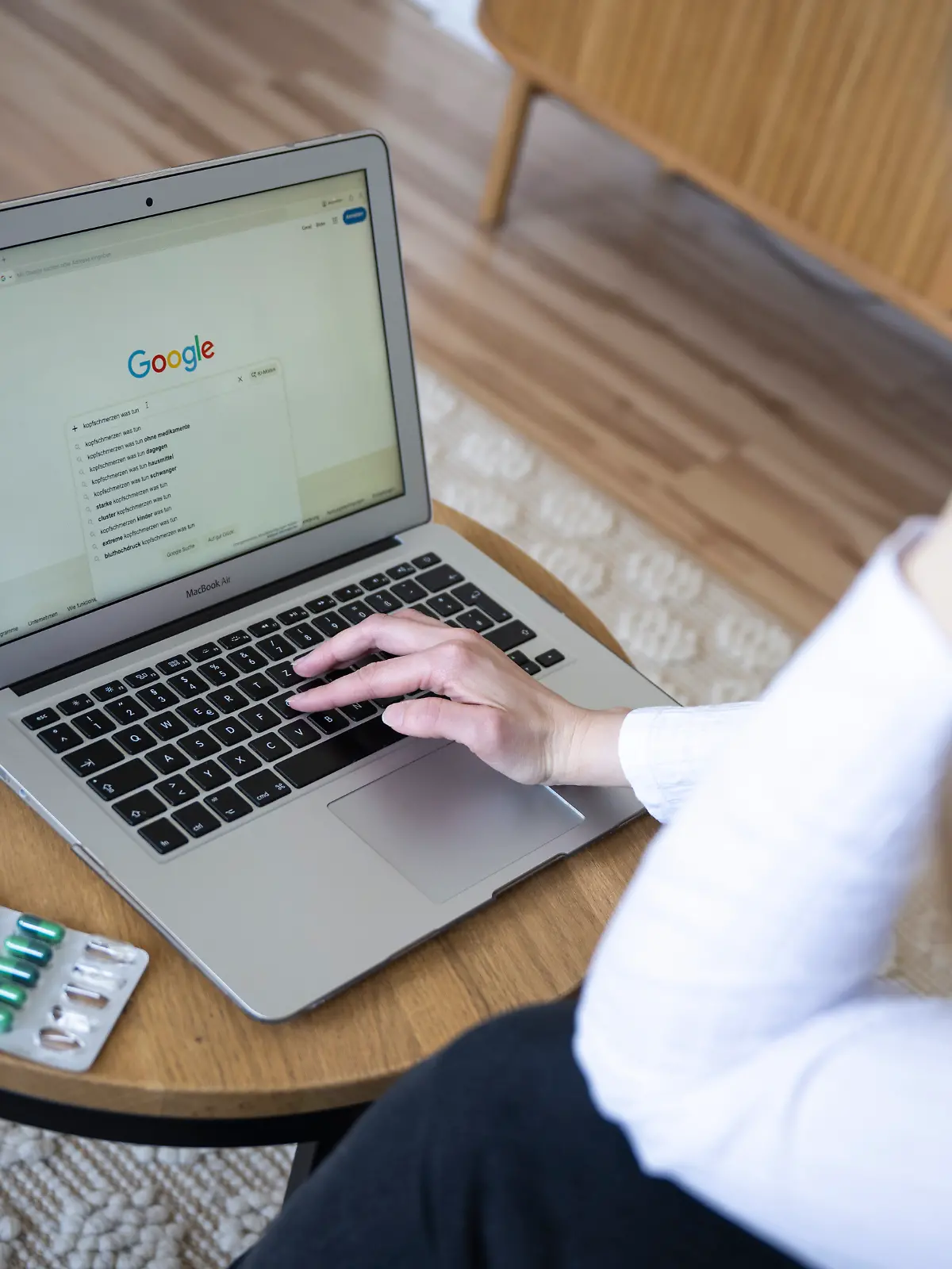 Eine Person gibt in die Google-Suche «Kopfschmerzen was tun» ein, daneben liegen Tabletten in einer Blisterpackung. Viele Menschen informieren sich online zu gesundheitlichen Beschwerden, was neben Informationen auch Verunsicherung auslösen kann. (zu dpa: «Cyberchondrie: Googeln, bis man zum Arzt muss») +++ dpa-Bildfunk +++