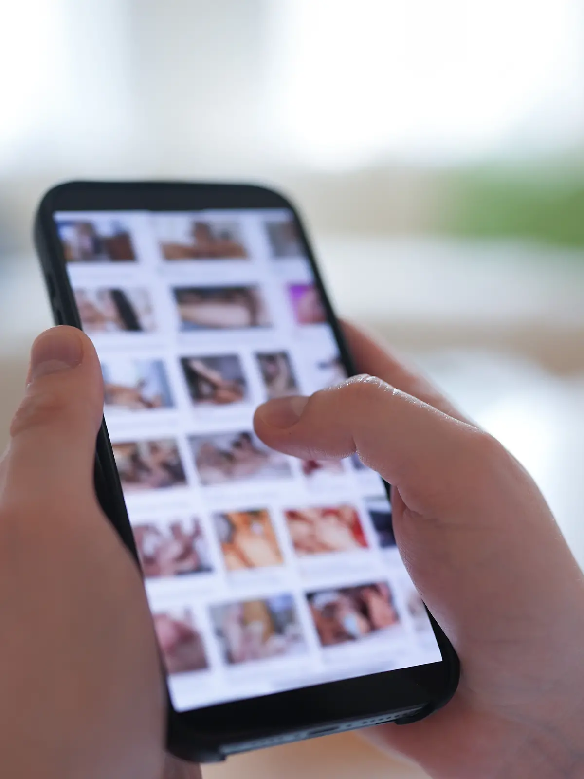 ILLUSTRATION - Ein junger Mann schaut sich auf einem Smartphone eine Porno-Internetseite an (gestellte Szene). (zu dpa: «Gesetz gegen digitale Gewalt «auf der Zielgeraden»») +++ dpa-Bildfunk +++