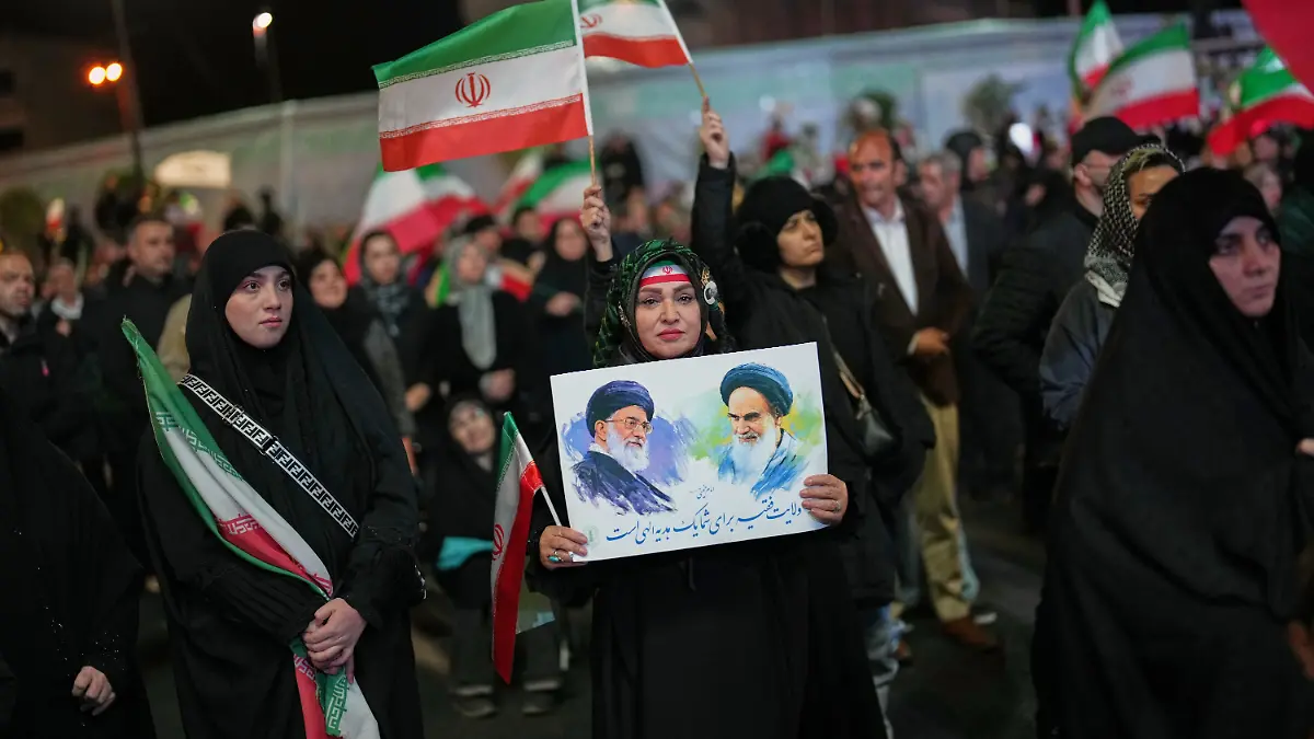 Eine Frau hält ein Plakat mit dem verstorbenen Obersten Führer Chamenei (l) und dem verstorbenen Revolutionsgründer Chomeini, während einer regierungsfreundlichen Versammlung in Teheran. +++ dpa-Bildfunk +++