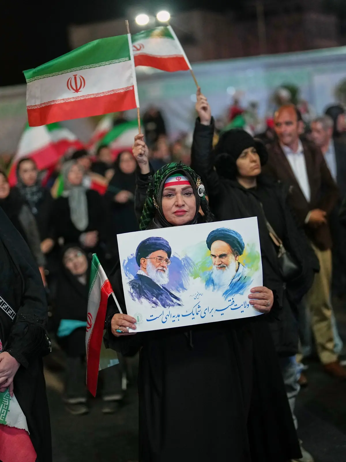 Eine Frau hält ein Plakat mit dem verstorbenen Obersten Führer Chamenei (l) und dem verstorbenen Revolutionsgründer Chomeini, während einer regierungsfreundlichen Versammlung in Teheran. +++ dpa-Bildfunk +++