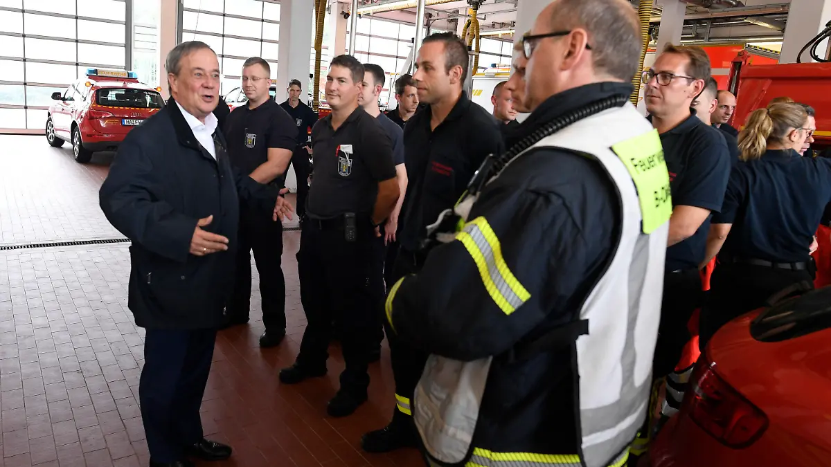 dpatopbilder - 15.07.2021, Nordrhein-Westfalen, Hagen: Der nordrhein-westfälische Ministerpräsident Armin Laschet (CDU, l) bedankt sich bei Hagenern Feuerwehrleuten für ihren Einsatz, nachdem er sich ein Bild von der Lage in der Stadt gemacht hat. Starkregen hatte zu Überschwemmungen in der Stadt geführt. Foto: Roberto Pfeil/dpa +++ dpa-Bildfunk +++