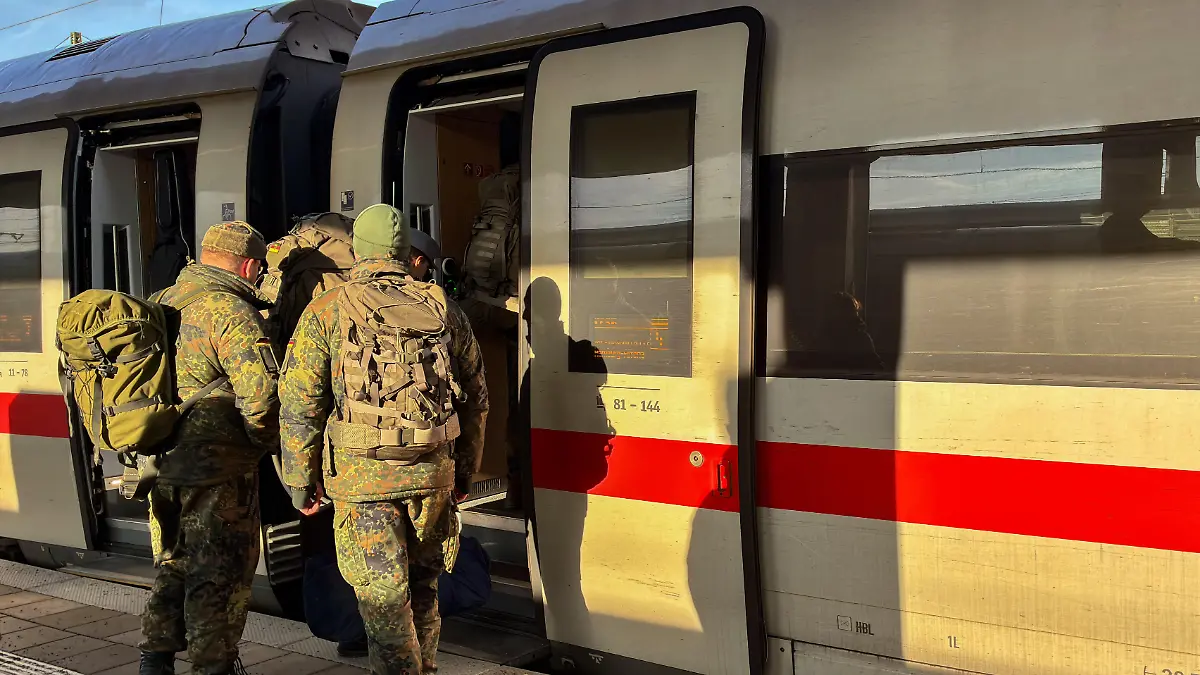 Several German Bundeswehr soldiers wear camouflage uniforms and large backpacks as they board an ICE train car on a platform in Munich, Bavaria, Germany, on December 12, 2025. (Photo by Michael Nguyen/NurPhoto)