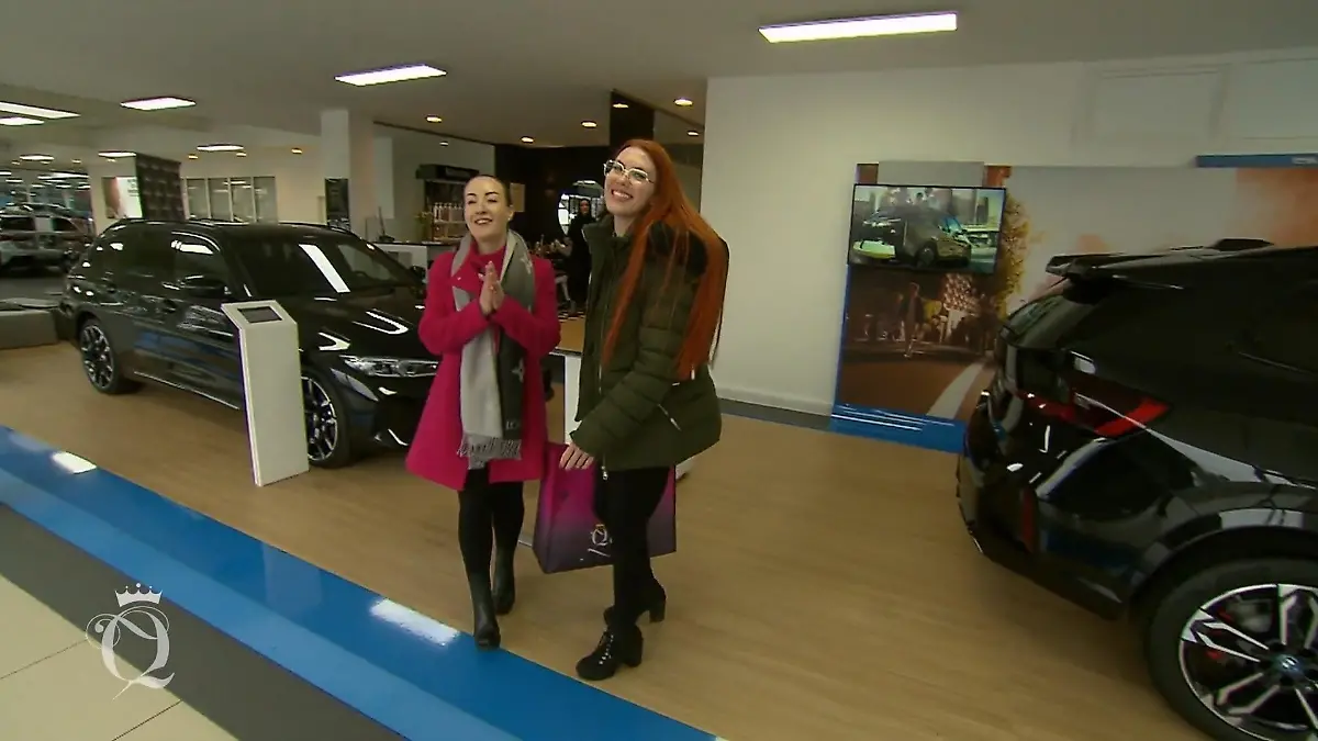 Tanja und Shopping-Begleitung stehen im Verkaufsraum eines Autohauses