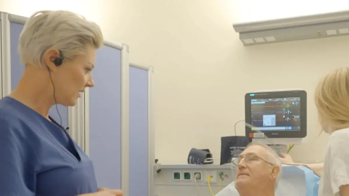 Mann mit hochgezogenem T-Shirt liegt im Krankenbett