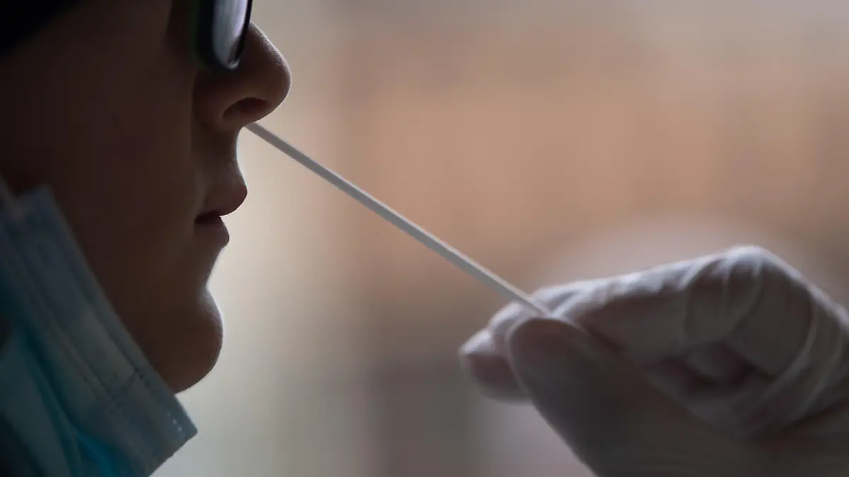 ARCHIV - 16.02.2021, Baden-Württemberg, Tübingen: An einer Frau wird ein Corona-Schnelltest vorgenommen. Wegen Problemen beim Datenschutz und der Übertragung von Corona-Testergebnissen hat die Stadt Bühl dem Betreiber eines Testzentrums gekündigt. (zu dpa «Bühl kündigt Testzentrum-Betreiber wegen EDV- und Datenschutzmängeln») Foto: Sebastian Gollnow/dpa +++ dpa-Bildfunk +++