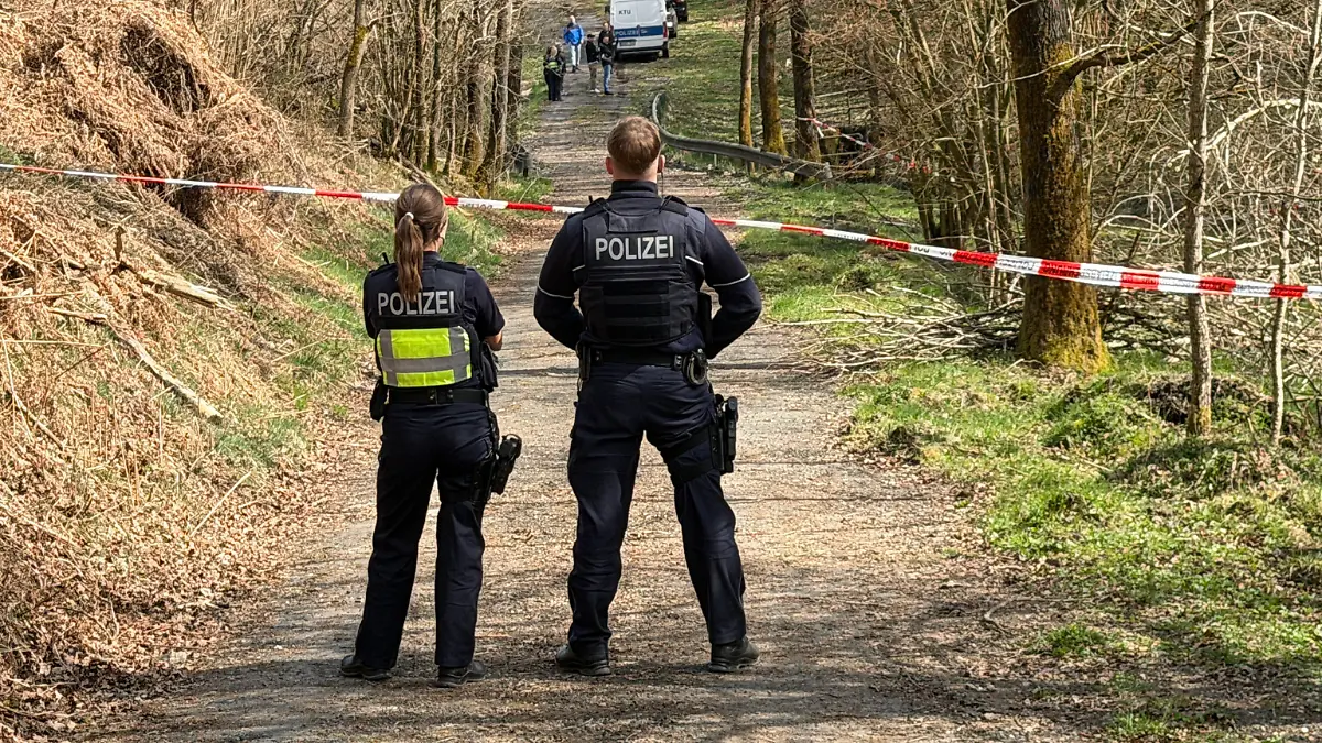 Kräfte der Polizei sind in einem mit Flatterband abgesperrten Bereich eines Waldes im Einsatz. Bei einer Müllsammelaktion wurde unweit der A4 ein menschlicher Kopf gefunden. +++ dpa-Bildfunk +++