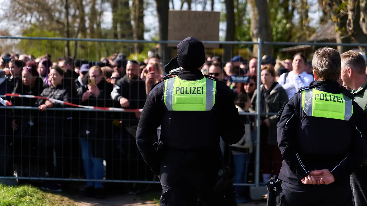 Teilnehmer einer Demonstration für die Rettung des Buckelwals stehen hinter einer Polizeiabsperrung. Seit zwölf Tagen treibt der verletzte Wal in der Wismarbucht vor der Insel Poel und zeigt weiterhin Lebenszeichen. +++ dpa-Bildfunk +++