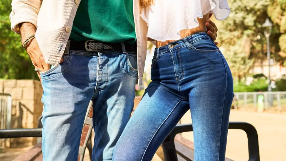 Mann mit Jeans und Hemd legt den Arm um eine Frau in enger Jeans und Boho-Bluse.