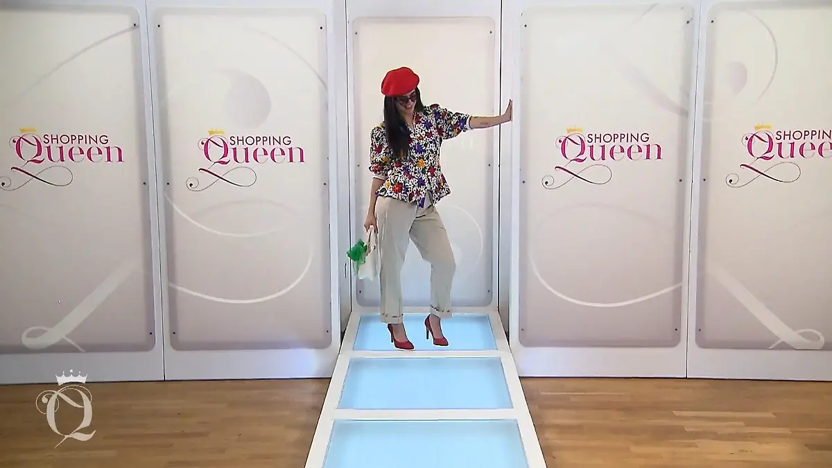 Shopping Queen: Junge Frau mit langen schwarzen Haaren, roter Baskenmütze, Sonnenbrille, roten Pumps, weißer Hose und bunt bedruckter Blüten-Bluse auf dem Catwald