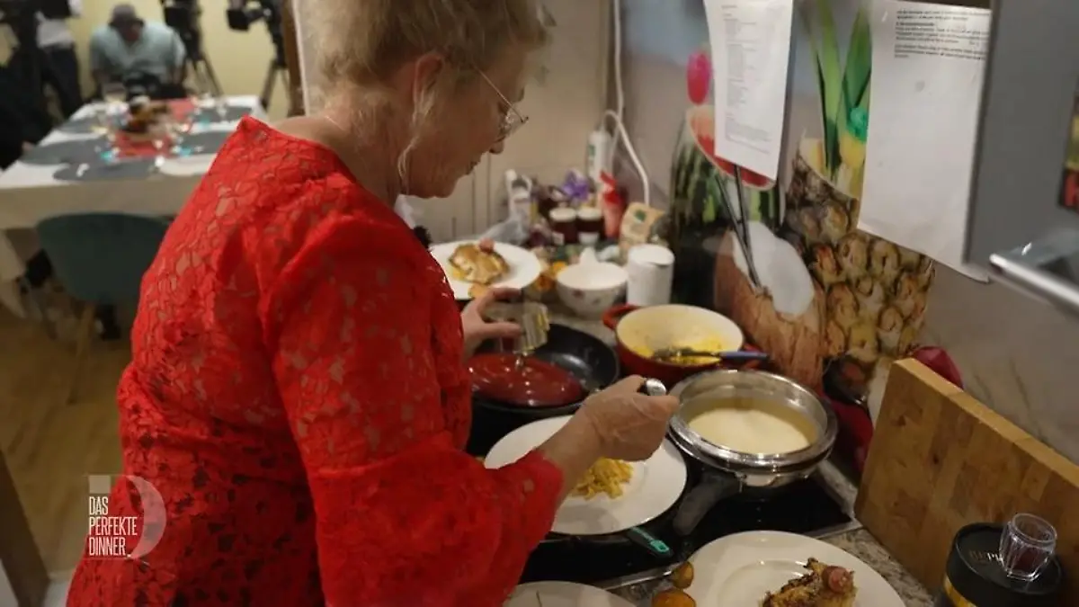 Lucia in der Küche wie sie das Risotto anrichtet, mehrere Töpfe und Teller stehen vor ihr.