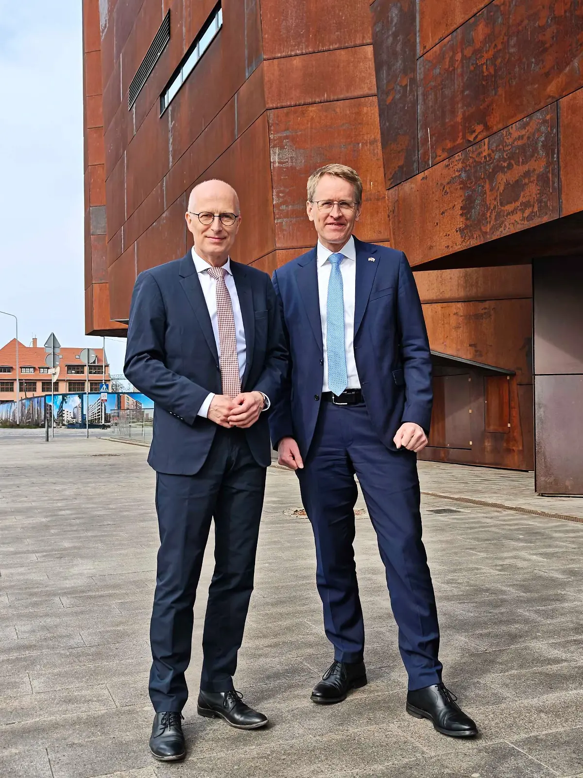 Hamburgs Bürgermeister Peter Tschentscher (SPD, l) und Schleswig-Holsteins Ministerpräsident Daniel Günther (CDU) stehen vor dem Europäischen Zentrum der Solidarnosc (Solidarität). 