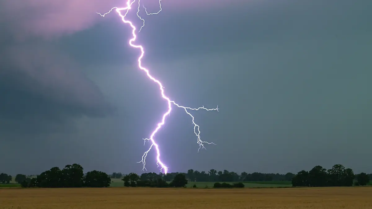 ARCHIV - 21.06.2024, Brandenburg, Heinersdorf: Ein Blitz leuchtet über einer Landschaft auf. (zu dpa: «Wo es am Himmel über dem Saarland besonders oft blitzt») Foto: Patrick Pleul/dpa +++ dpa-Bildfunk +++