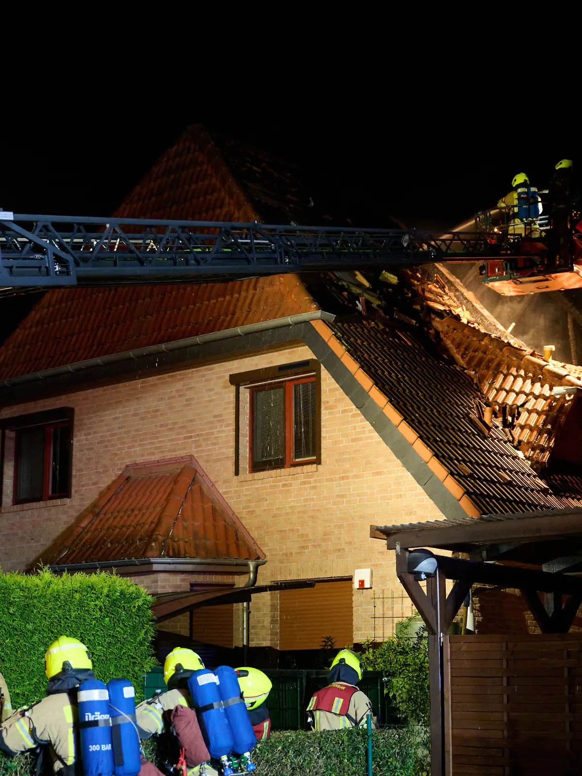 Einsatzkräfte der Feuerwehr stehen auf einer Feuerwehrleiter und löschen einen Brand in Marzahn. Von den Bewohnern sind zwei Menschen gestorben, vier wurden verletzt. Zwei weitere Bewohner werden gesucht. Polizei und Staatsanwaltschaft ermitteln wegen des Verdachts auf Mord und Mordversuch. (zu dpa: «Nach tödlichem Brand – Verdächtiger 28-Jähriger festgenommen») +++ dpa-Bildfunk +++