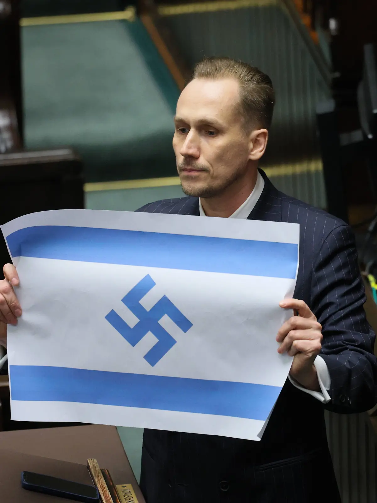 Konrad Berkowicz, Abgeordneter im Sejm in Warschau, Polen, hält eine israelische Flagge mit einem Hakenkreuz. +++ dpa-Bildfunk +++
