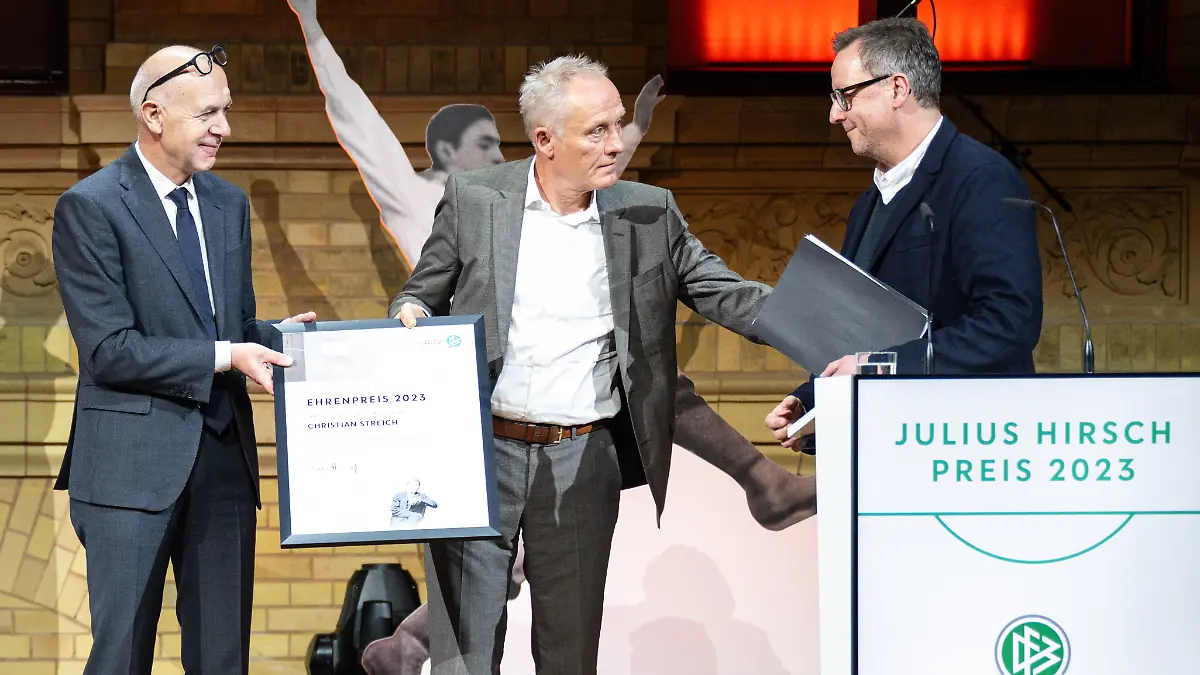 DFB-Präsident Bernd Neuendorf (l) überreicht den Ehrenpreis an Christian Streich (M), Fußballtrainer des SC Freiburg. Mit dem Julius-Hirsch-Preis ehrt der DFB Vereine und Persönlichkeiten für ihren Einsatz gegen Antisemitismus.