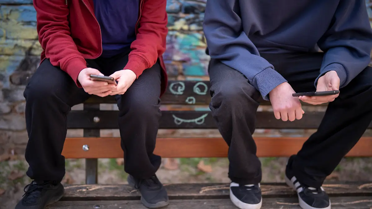Jugendliche schauen in ihre Handys in Frankfurt am Main (Foto vom 08.03.2026).