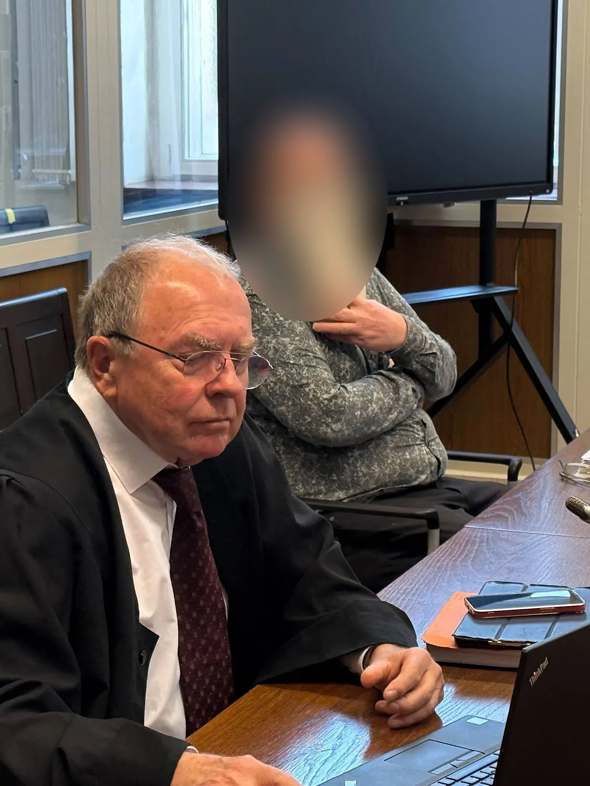 Der Angeklagte sitzt in einem Gerichtssaal.