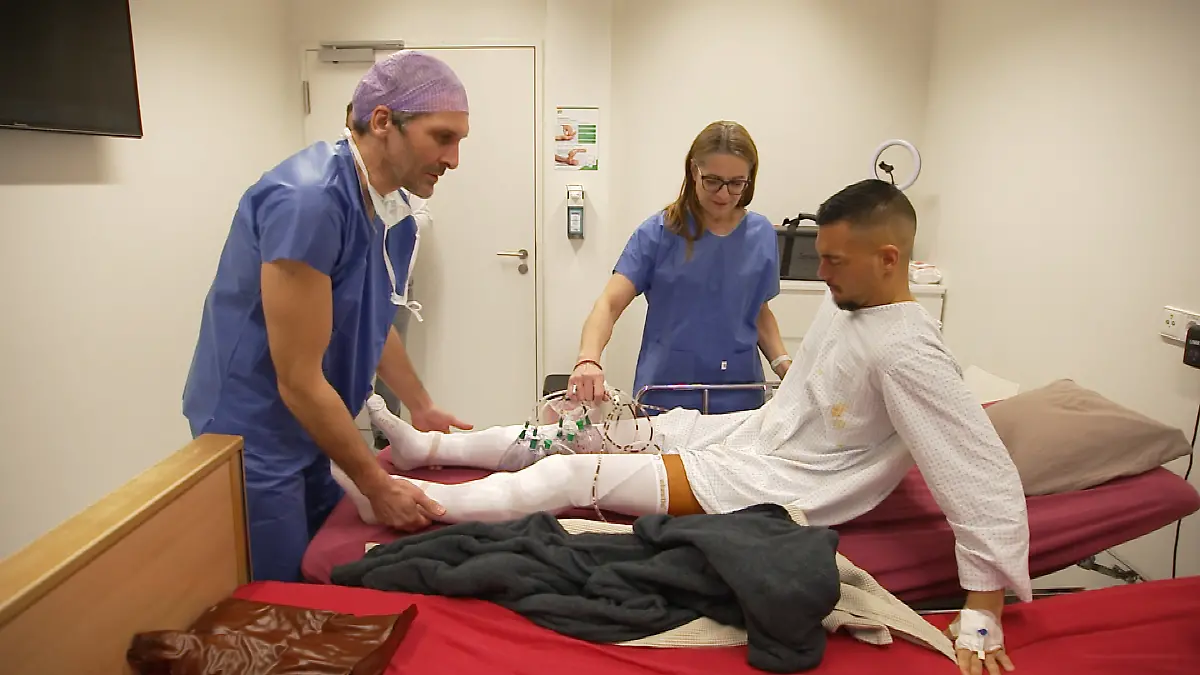 Für immer jung: Junger Mann im OP-Hemd mit verbundenen Beinen im Behandlungsraum