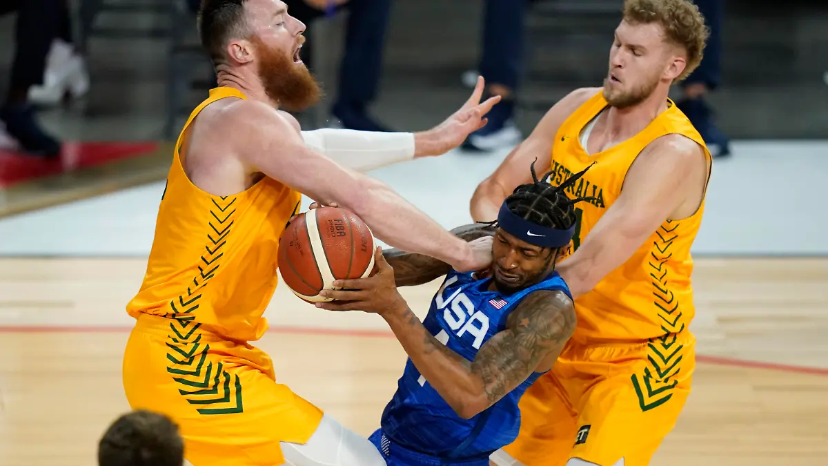 United States' Bradley Beal drives into Australia's Aron Baynes, left, and Jock Landale, right, during an exhibition basketball game Monday, July 12, 2021, in Las Vegas. (AP Photo/John Locher)