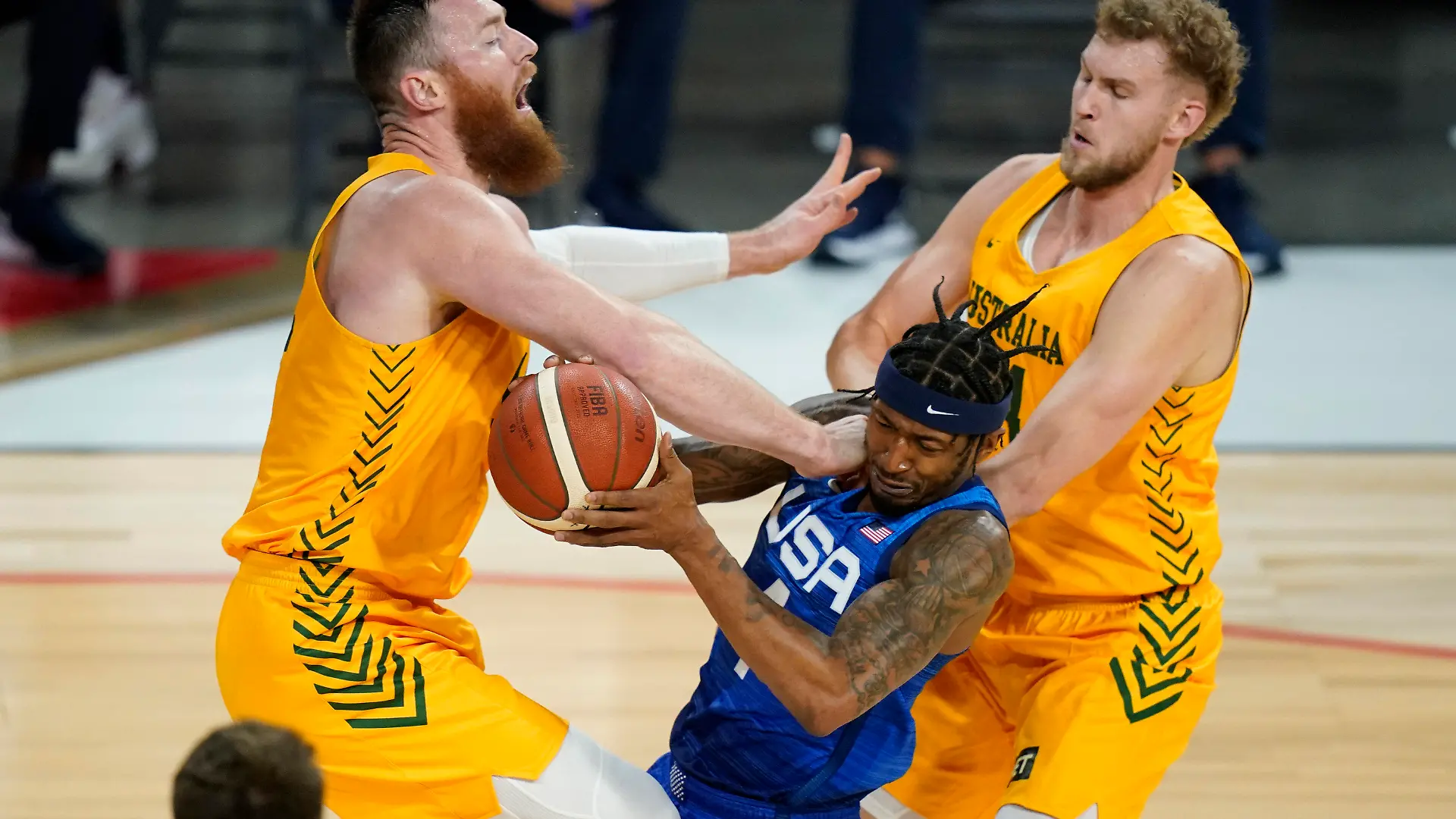 United States' Bradley Beal drives into Australia's Aron Baynes, left, and Jock Landale, right, during an exhibition basketball game Monday, July 12, 2021, in Las Vegas. (AP Photo/John Locher)