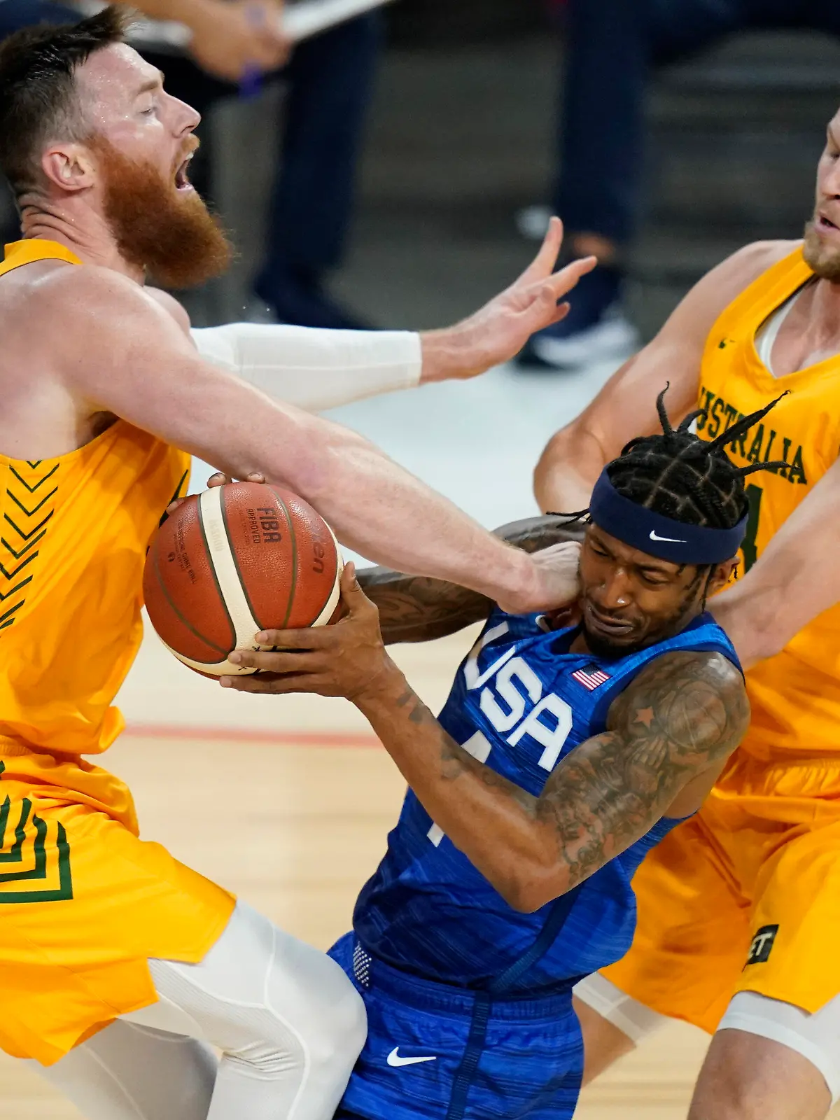 United States' Bradley Beal drives into Australia's Aron Baynes, left, and Jock Landale, right, during an exhibition basketball game Monday, July 12, 2021, in Las Vegas. (AP Photo/John Locher)