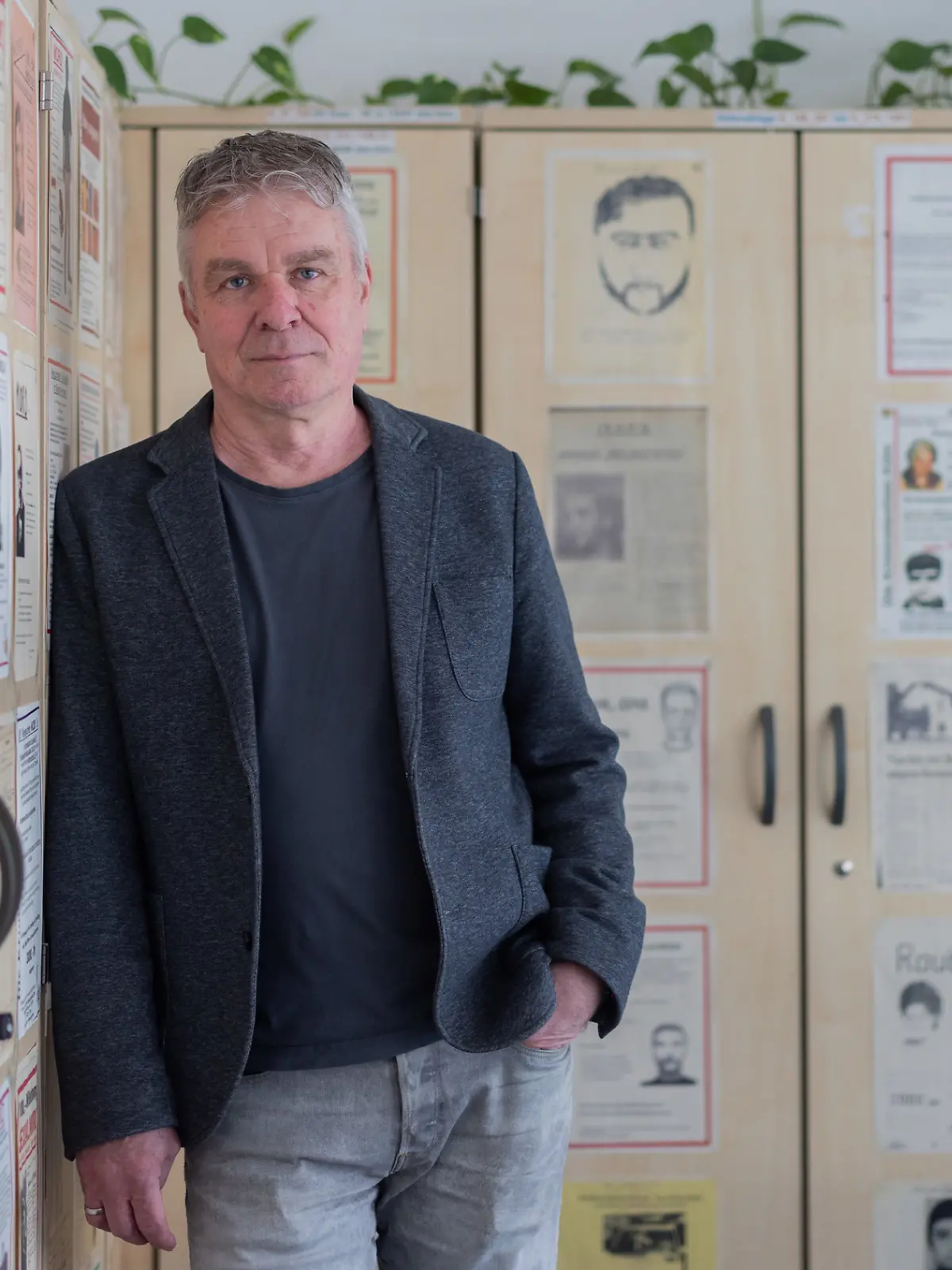 PRODUKTION - 25.03.2026, Nordrhein-Westfalen, Köln: Markus Weber, Leiter Ermittlungsgruppe Cold Cases der Kölner Polizei, steht in einem Büro im Polizeipräsidium vor Büroschränken, auf denen Fahndungsplakate mit ungelösten Fällen hängen. Seit 2022 ist er Leiter der damals neu gegründeten Abteilung Cold Cases bei der Kölner Polizei. In Köln und Umgebung gibt es nach Schätzung von Weber mehr als 250 offene sogenannte Cold Cases - jahrzehntelang zurückliegende Verbrechen, die bis heute nicht gelöst sind. (zu dpa "Von Cold Cases und heißen Spuren - Ein Mordermittler erzählt") Foto: Rolf Vennenbernd/dpa - ACHTUNG: Verwendung nur in vollem Format und nur bis zum Ende der Öffentlichkeitsfahndung der Polizei +++ dpa-Bildfunk +++