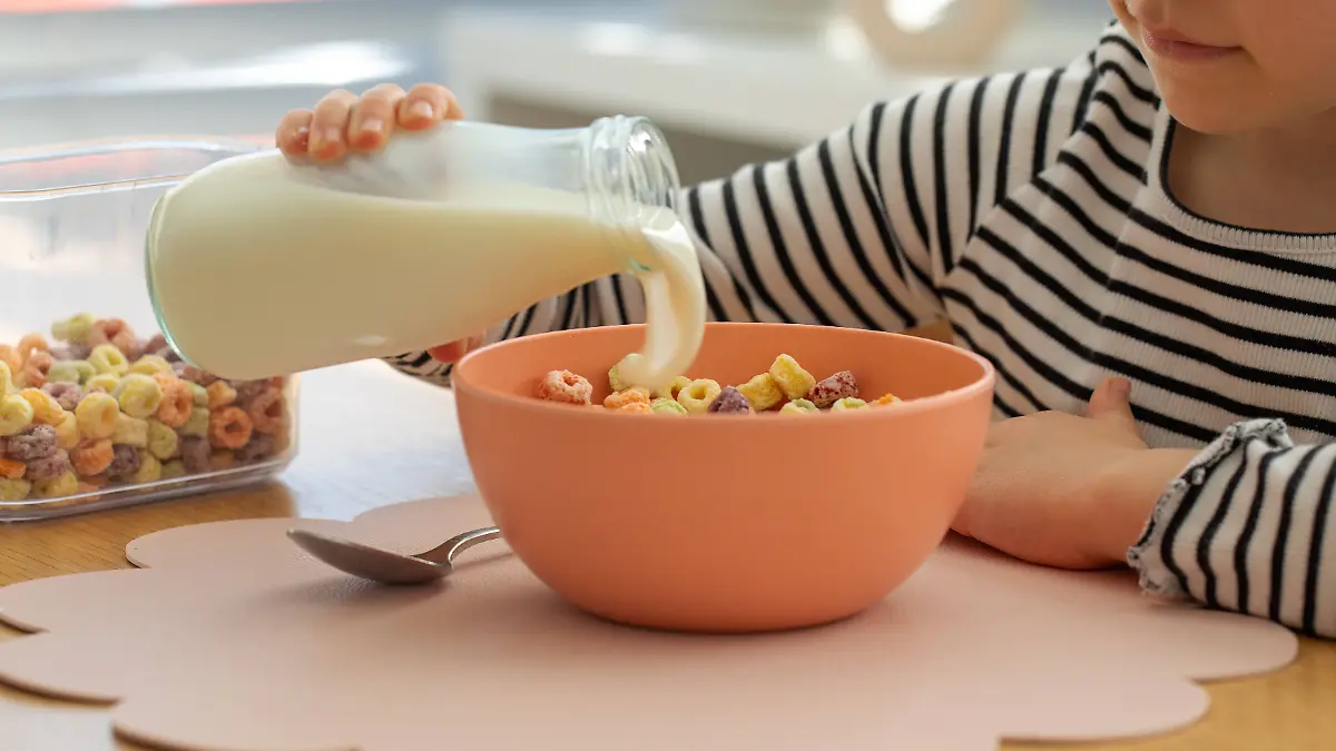 Niedliches kleines Mädchen gießt frische Milch aus der Flasche in bunte Frühstücksflocken. Trockenes Müsli. Cute little girl pouring fresh milk from bottle into colorful breakfast cereal. Children s breakfast concept, dry cereal. LicenseRF ,model released, Symbolfoto Copyright: xZoonar.com/ViktoriiaxPopovax 23653895 ,model released, Symbolfoto ,property released