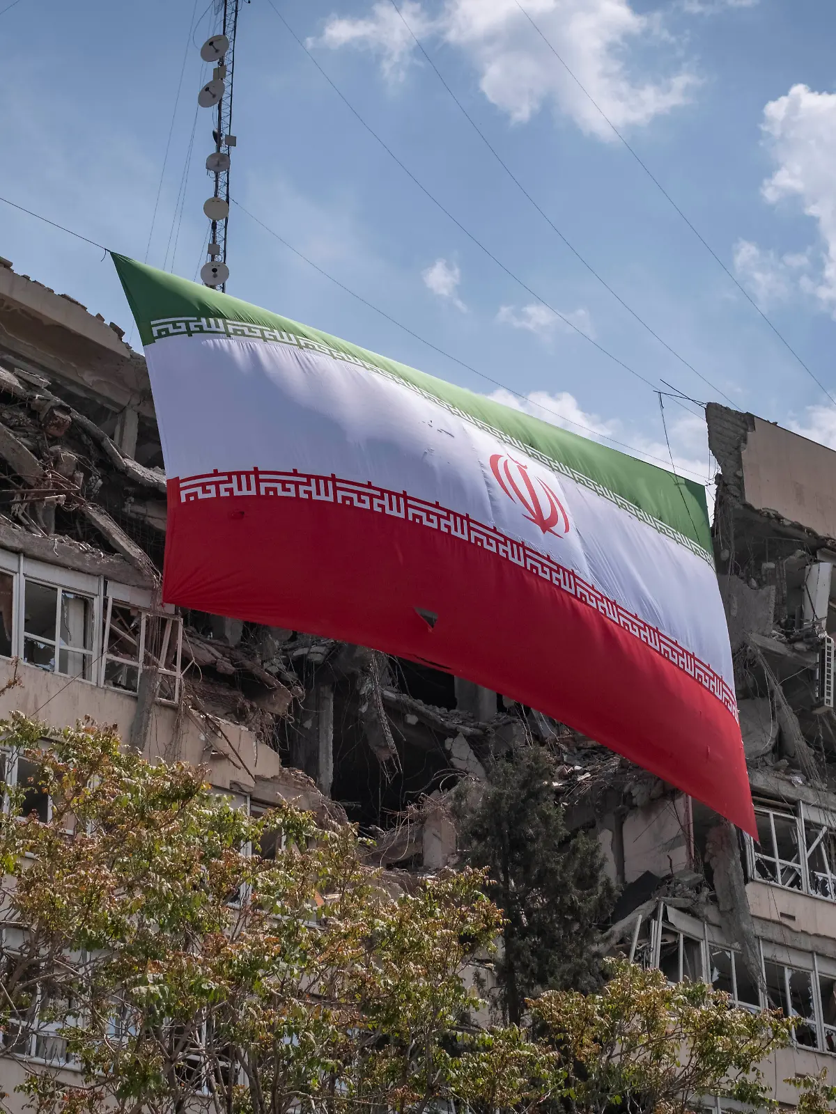 Iran War - Destroyed Sites An Iranian national flag hangs from the Judiciary s headquarters, which was damaged in a military operation in Tehran, Iran, on April 20, 2026. Tehran Iran PUBLICATIONxNOTxINxFRA Copyright: xMortezaxNikoubazlx originalFilename: nikoubazl-iranward260420_npyjJ.jpg