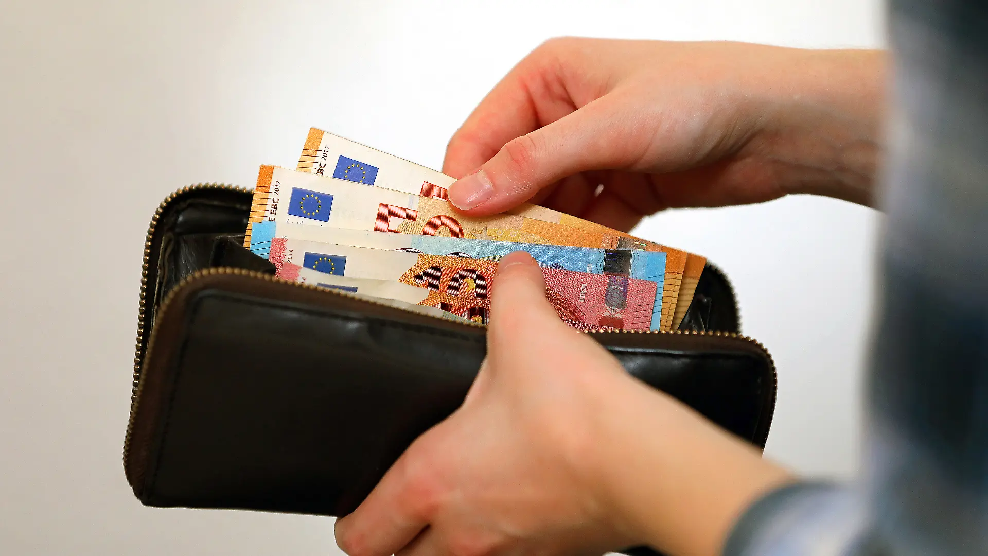 Symbolbild: Eine Frau zählt ihre Geldscheine ihrem Portemonnaie. In Zeiten von steigenden Energiekosten müssen viele Bürger den sparen.