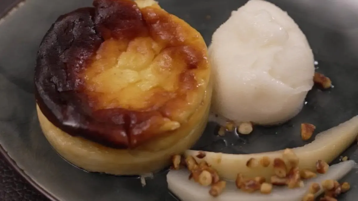 Detail des Desserts: kleiner Käsekuchen mit Birnenspalten daneben