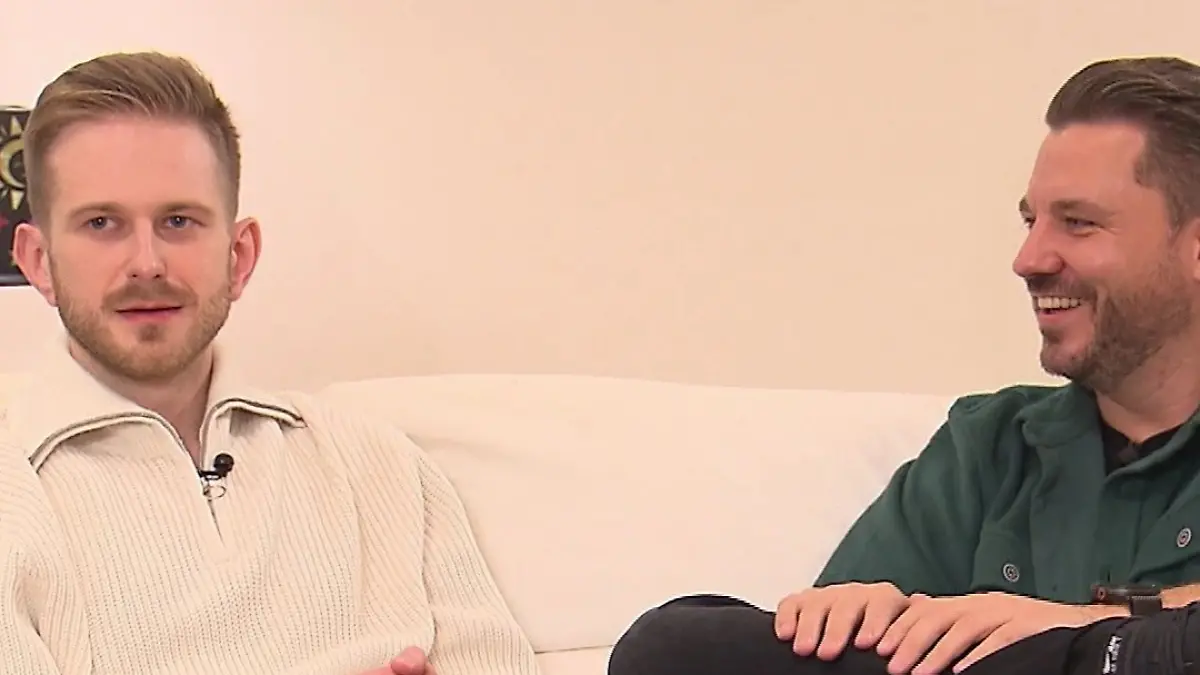 Zwei Gäste auf dem Sofa.