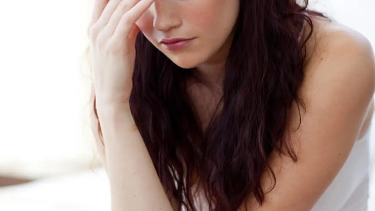 Beautiful woman having a headache sitting in bed