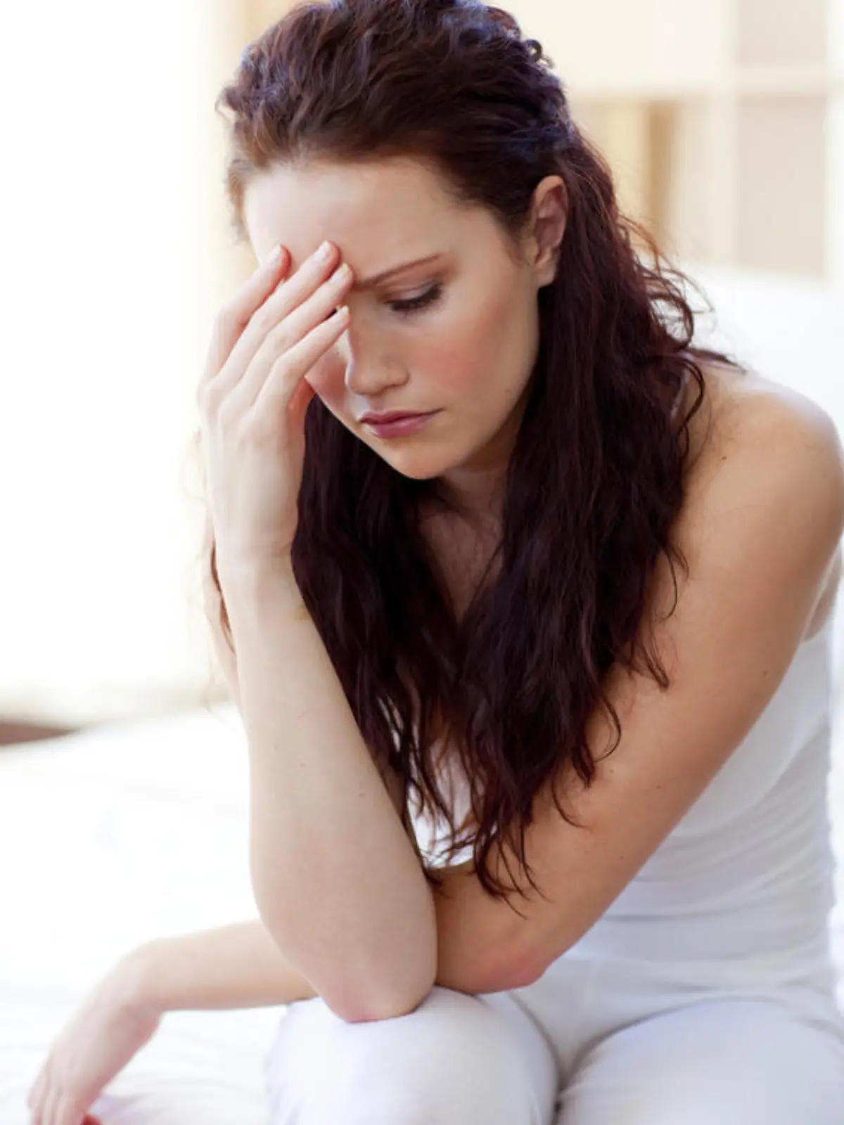 Beautiful woman having a headache sitting in bed