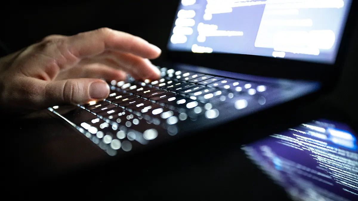 Eine Person tippt mit den Fingern auf einer beleuchteten Laptop-Tastatur. (gestellte Szene) (zu dpa: «Cyber-Angriff auf Centro: Hacker erbeuten Kundendaten») +++ dpa-Bildfunk +++