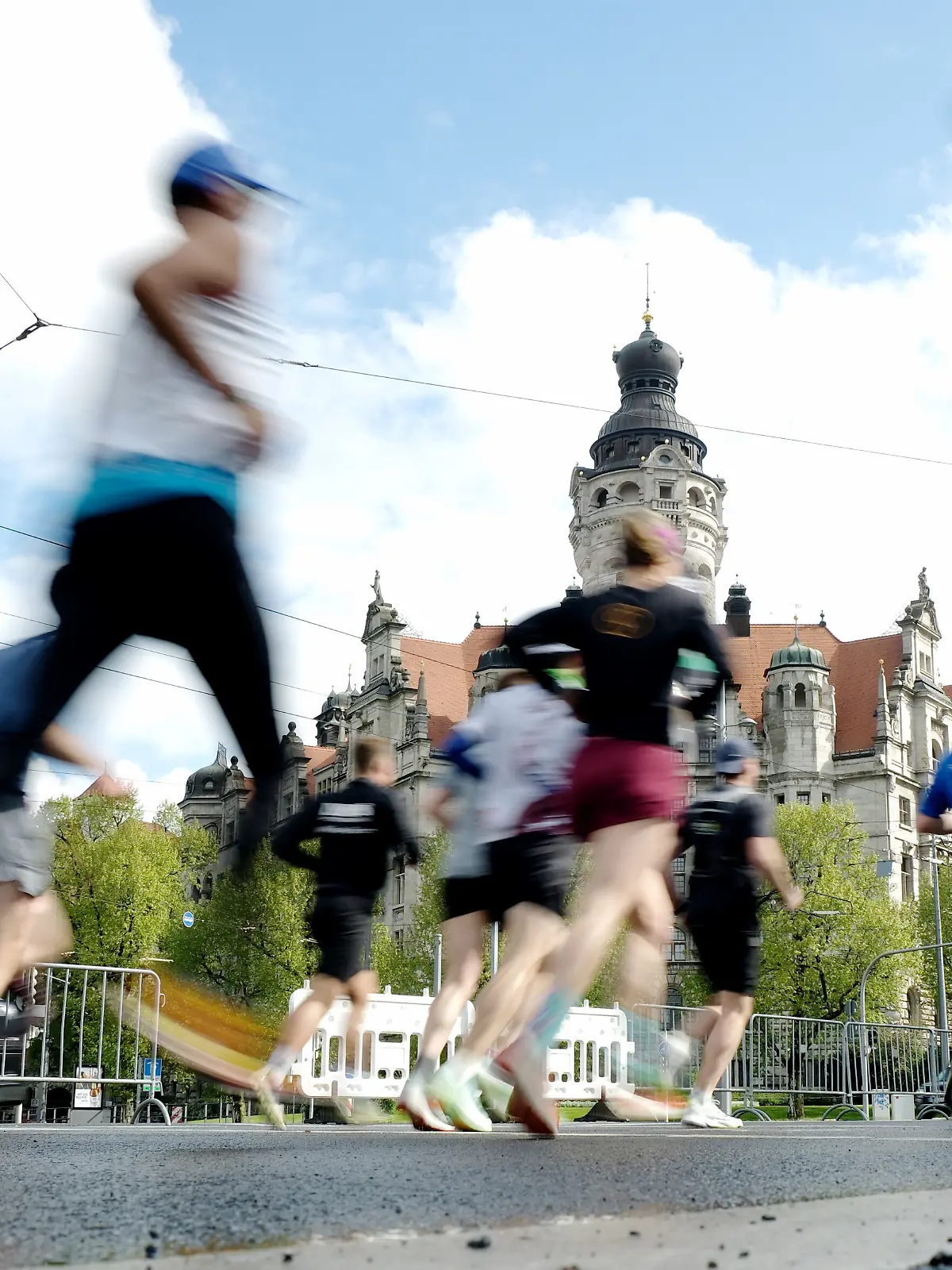 Marathonläufer bewegen sich am Neuen Rathaus vorbei. Etwa 9000 Menschen gehen am Sonntag beim 46. Leipzig Marathon in verschiedenen Disziplinen, wie Handbikes oder Inlineskates oder zu Fuß an den Start.