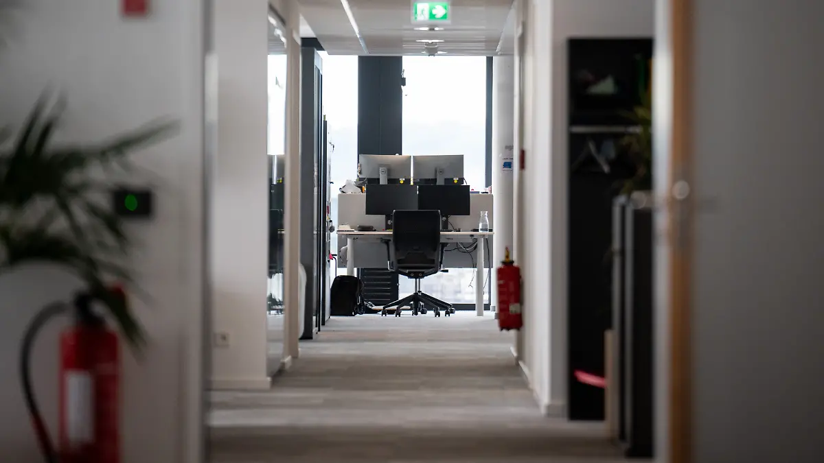 Ein leerer Arbeitsplatz ist am Ende eines Gangs in einem Büro.