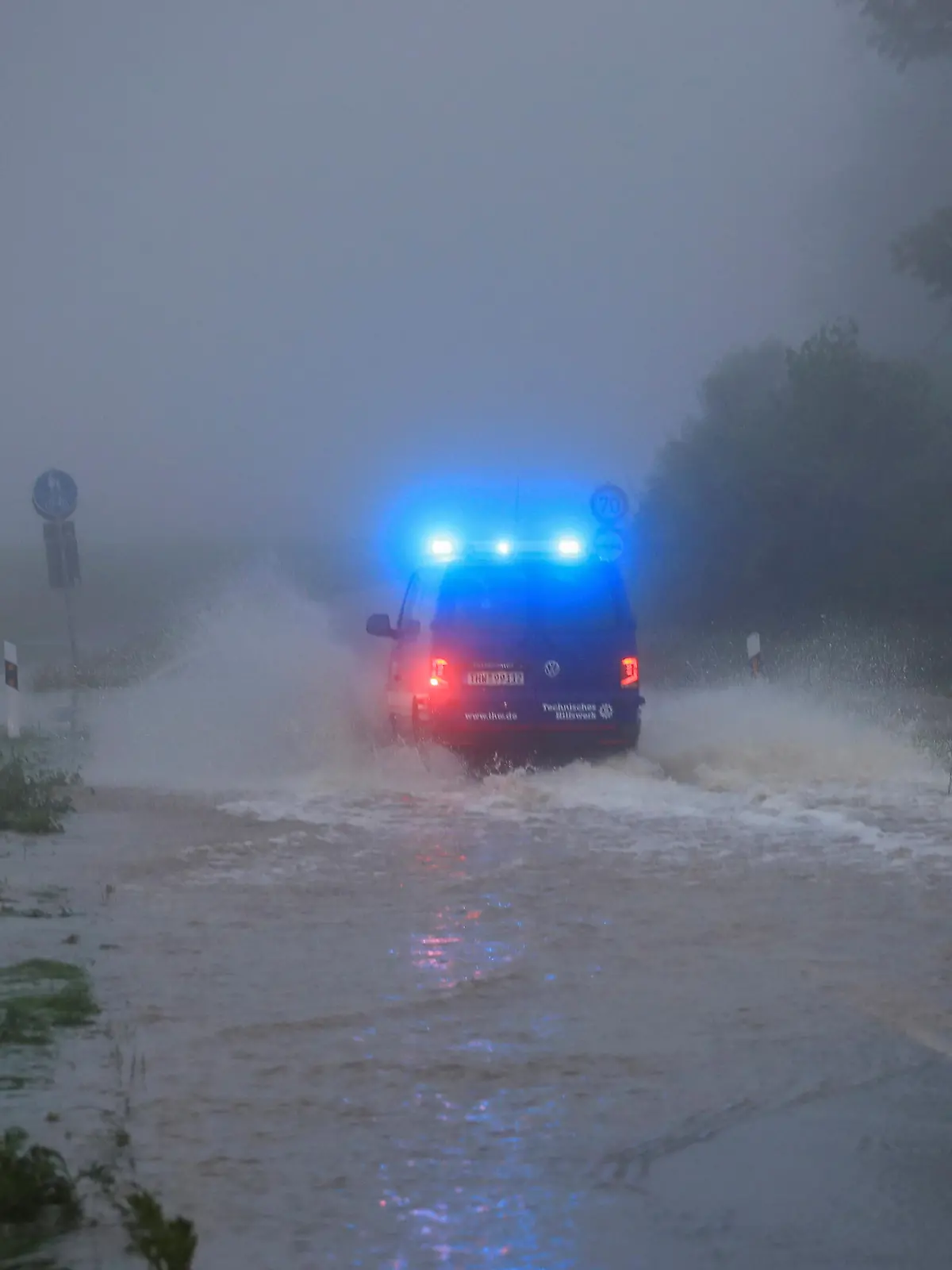 A vehicle travels on a flood affected road after the Erft river swelled following heavy rainfalls in Erftstadt, near Cologne, Germany, July 15, 2021. REUTERS/Wolfgang Rattay